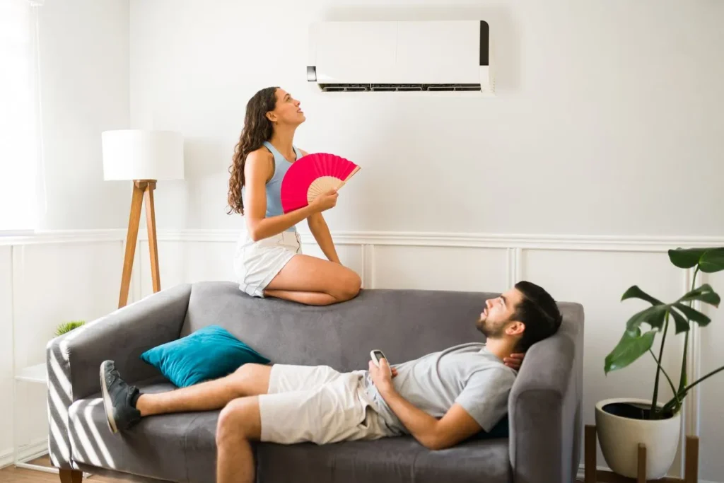 Couple sitting underneath AC not cooling
