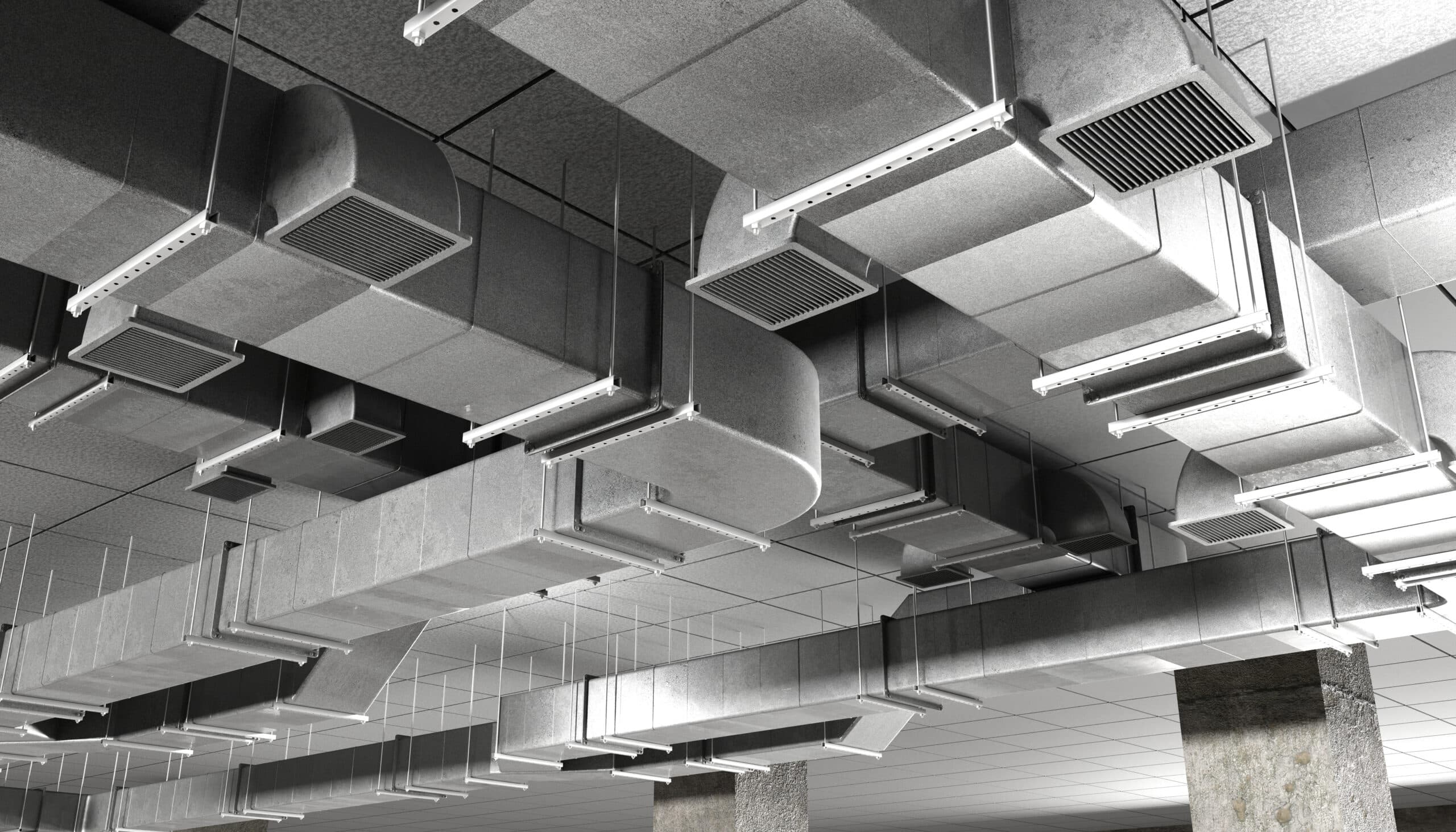 Ceiling view showing metal ductwork and ventilation systems in a commercial space. The ducts are arranged in various shapes and sizes, with integrated lighting fixtures visible. A concrete column is partially seen in the image.